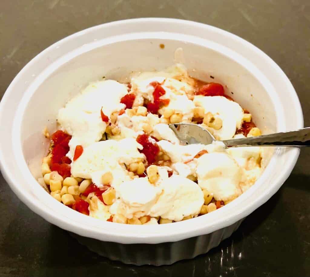 Corn, cream cheese, and rotel in bowl