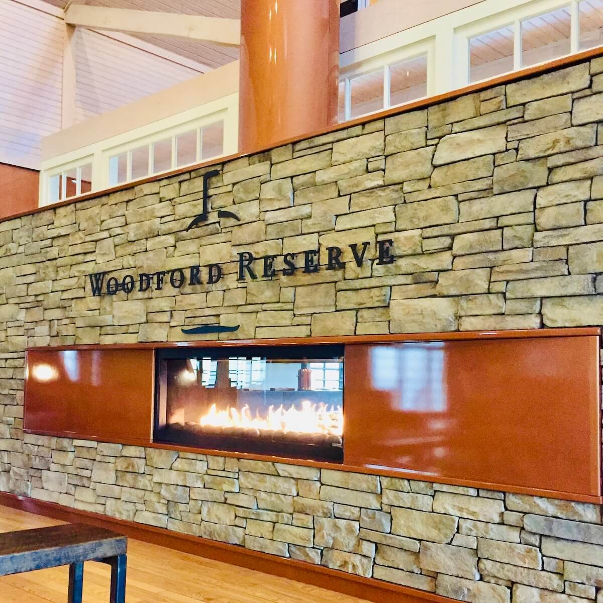 The see through fireplace inside the stone wall of the woodford reserve distillery visitor's center