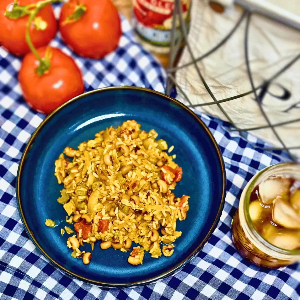 Hoppin john on blue plate with tomatoes