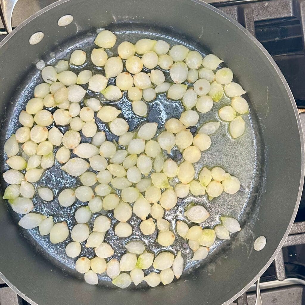 Pearl onions cooking in a pan