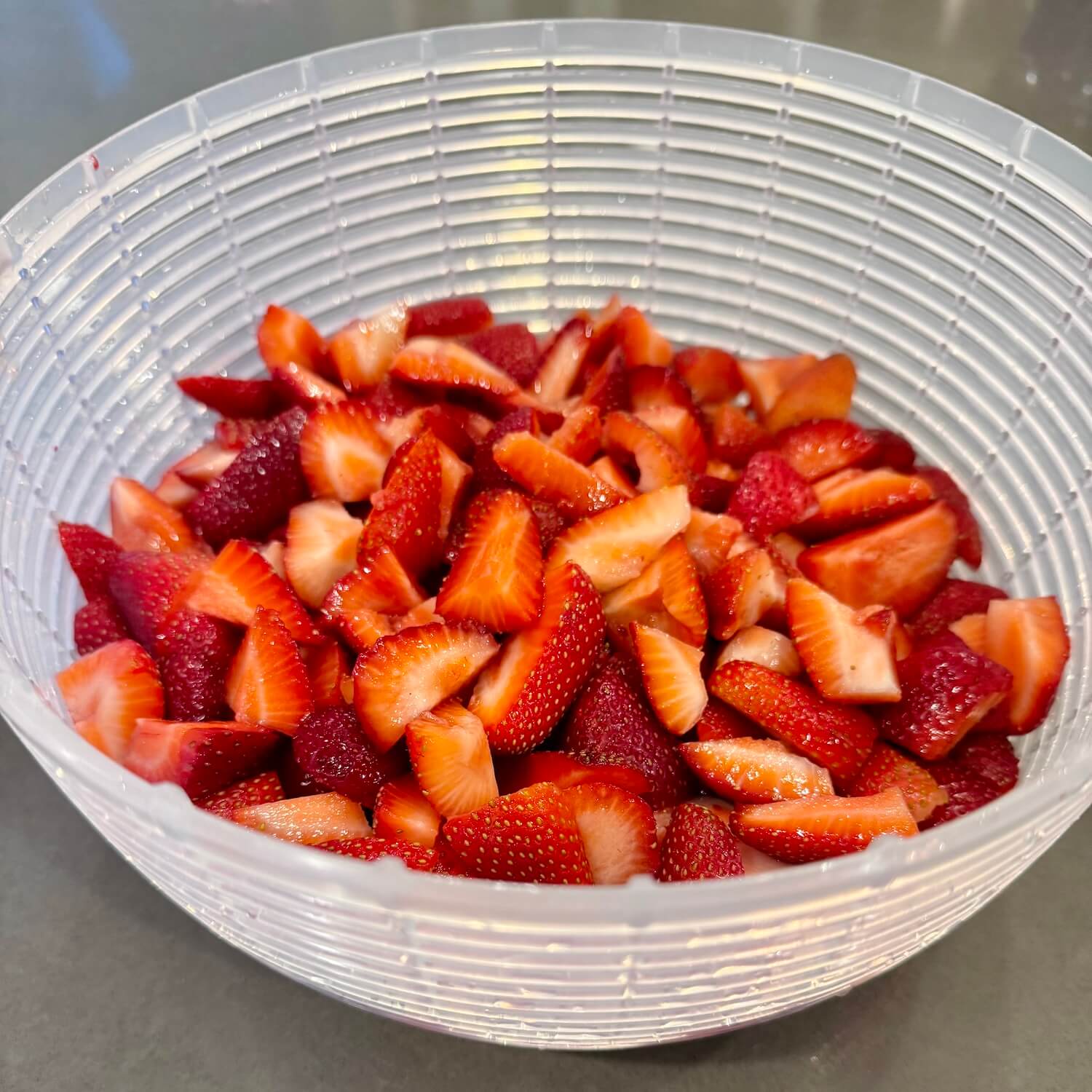 Quartered strawberries in colander